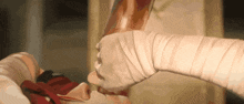 a person with a bandage on their arm is holding a knife in their hand .