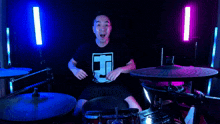 a man is making a heart shape with his hands while playing drums