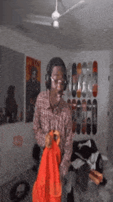 a man wearing headphones is holding an orange bag in a bedroom