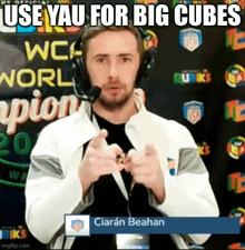 a man wearing headphones is pointing at the camera with the words `` use yau for big cubes '' written above him .