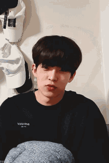 a young man wearing a black shirt that says ' squid ' on it