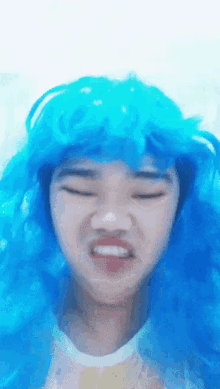 a woman wearing a blue wig makes a funny face