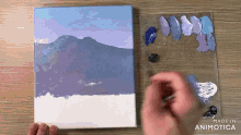 a person is painting a landscape on a canvas with the words made in animatica visible in the corner