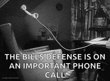 a black and white photo of a telephone hanging from a chair .