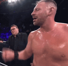 a man without a shirt is standing in a boxing ring with his eyes closed