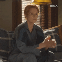 a woman sitting on a couch with a max logo in the background