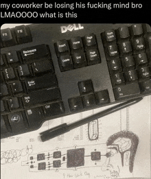 a dell keyboard sits next to a drawing of a man
