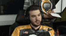 a man wearing headphones is sitting in a chair with a shirt that says ea on it