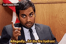 a man in a suit and tie is pointing at the camera and saying `` allegedly ... hit the fire hydrant '' .