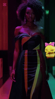a woman in a green dress is holding a yellow duck with a pink bow on its head