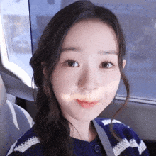 a close up of a girl 's face with a striped sweater on