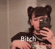 a girl is taking a picture of herself in a mirror with a cell phone .