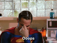 a man in a superman costume is covering his face with his hand and the word ooops is on the bottom