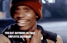 a man wearing a red hat and a jacket is smiling and says `` you got anymore of that employee discount '' .
