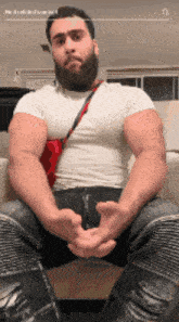 a man with a beard is sitting on a couch