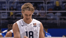 a man wearing a white usa jersey with the number 18 on it