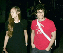 a man in a red shirt with the word national on it is standing next to a woman