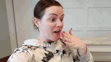 a woman with a surprised look on her face has pink nail polish on her nails