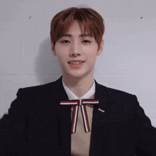 a young man wearing a bow tie and a suit