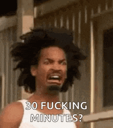 a man with a beard is making a funny face and saying `` 30 fucking minutes ? '' .