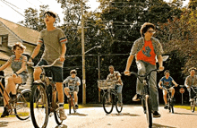 a group of people are riding bicycles down a road .