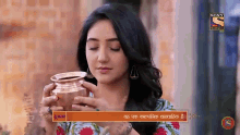 a woman is holding a pot of water in her hands and drinking from it .