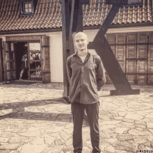 a man standing in front of a building that says franz kafka museum