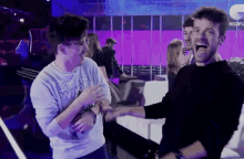 a man wearing a star wars sweatshirt holds another man 's hand