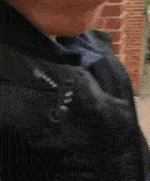 a close up of a person wearing a black jacket and a backpack
