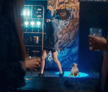 a woman is dancing in front of a wall with graffiti that says " pop "
