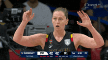 a woman in a belgium jersey stands in front of a sport hd screen