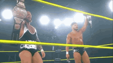 two wrestlers in a ring with one holding a belt