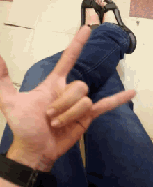a person wearing flip flops is making a devil horns sign