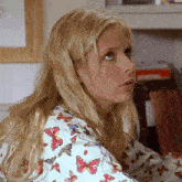a woman with blonde hair and a shirt with butterflies on it
