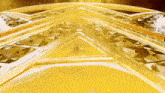 a close up of a gold colored object with a triangle pattern