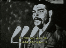 a man speaking into a microphone with the words " it 's what transforms men into blood thirsty beasts "