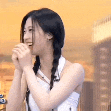 a woman with pigtails is smiling and laughing while holding her hands together .