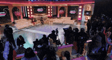 a crowd of people are gathered in front of a stage that has baddies hollywood written on it