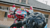 a robot is fighting a monster in front of a house