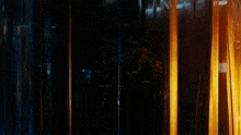 a man in a dark room with a reflection of himself in a glass door