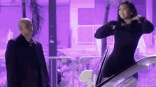 a woman in a black dress is getting out of a car .