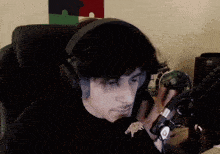 a man wearing headphones is sitting in front of a keyboard