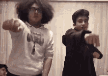 a couple of young men are dancing together in a living room .