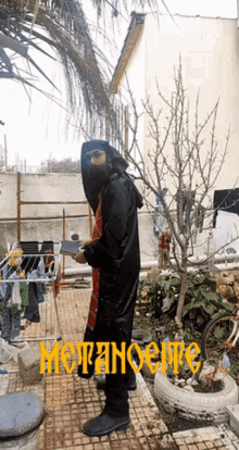 a man in a black costume is standing in front of a sign that says moranoene