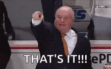a man in a suit and tie is pointing his finger at the camera .