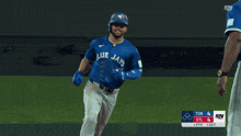 a blue jays player is running towards another player on the field