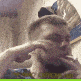 a man is making a funny face while smoking a cigarette in a room .