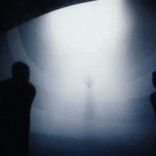 a person is standing in front of a large white light