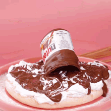 a can of nutella is being poured over a pizza
