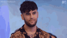 a man with a beard is wearing a shirt that says exonthe beach